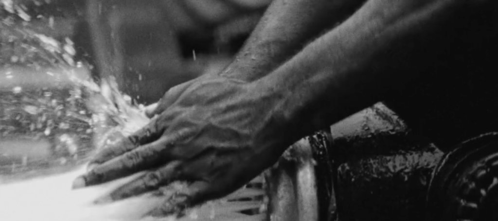 B&W two hands touching water at open fire hydrant