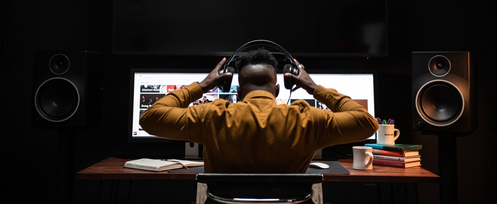 Sound editor at workstation with headphones