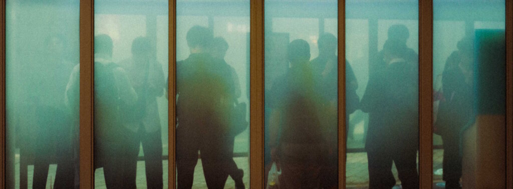 Figures Are Faintly Visible Through A Series Of Frosted Glass Panels