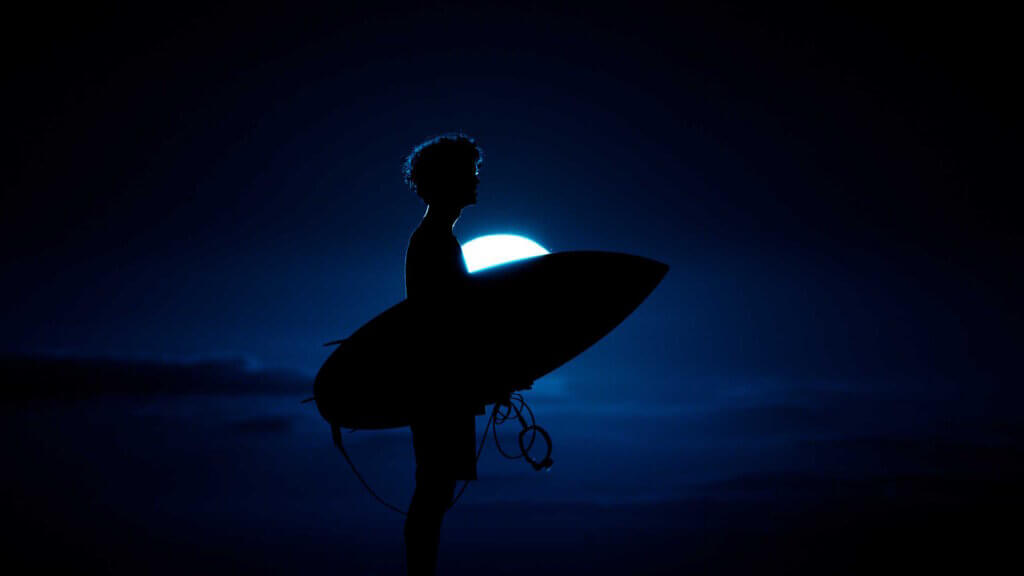 Surfer at night, with full moon
