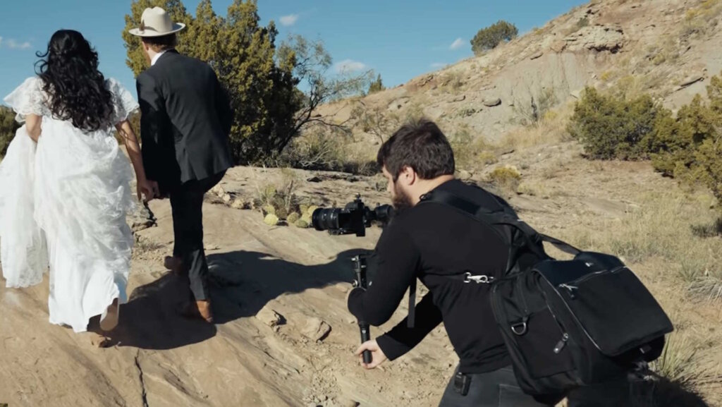 Wedding filmmaker filming a bride and a groom