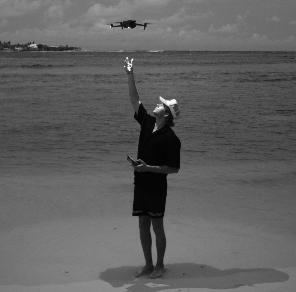 Luke Berg flying drone on beach
