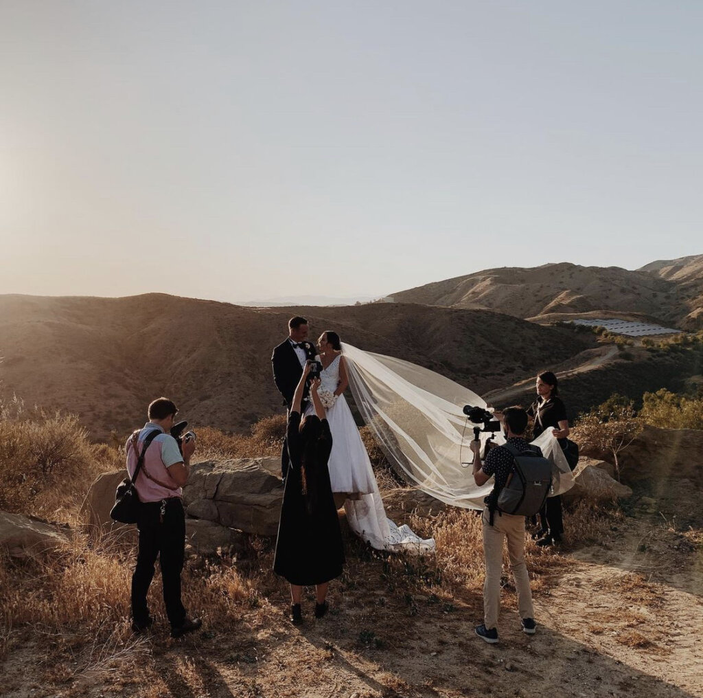 Wedding Film School filming couple in front of hills