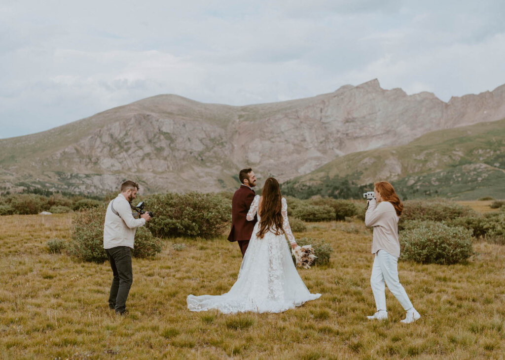 Brendan & Chloe Simpson filming couple in front of mountainscape on their wedding day