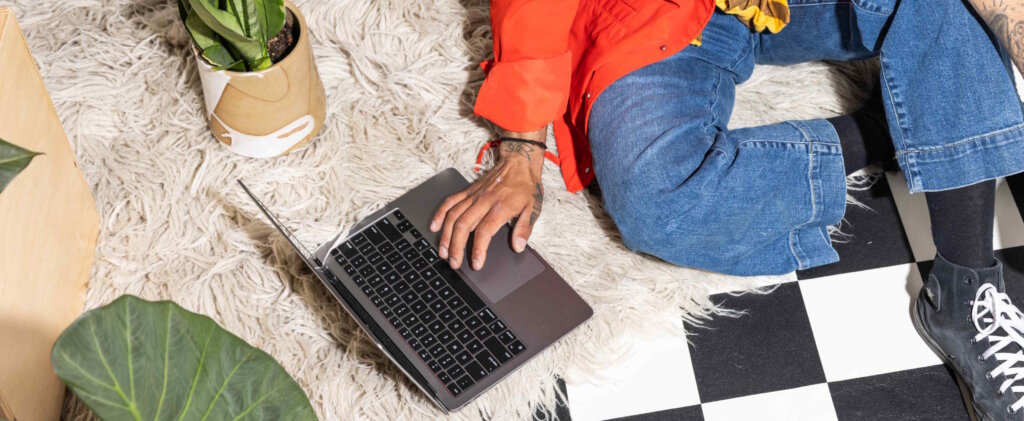 A Man Sits On A Rug With Potted Plants