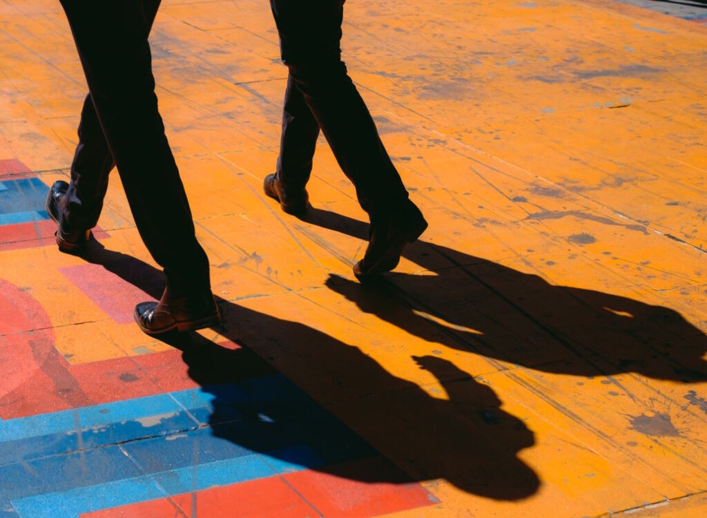 Two males walking with their shades behind them