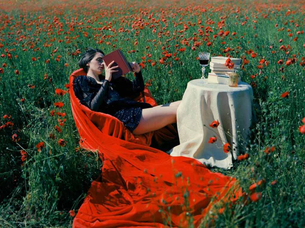 Young woman reading in a field of flowers