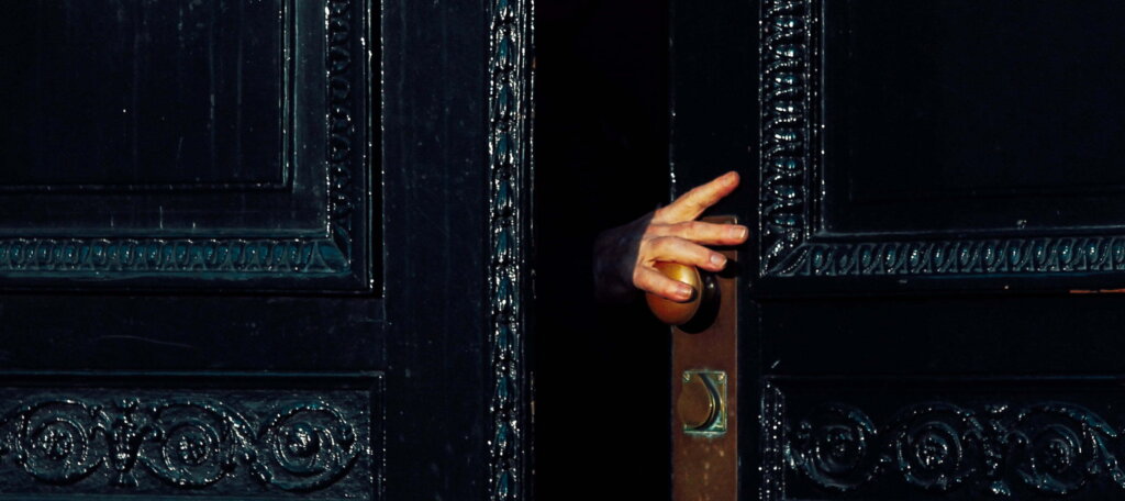 A Person Opens An Ornate Front Door