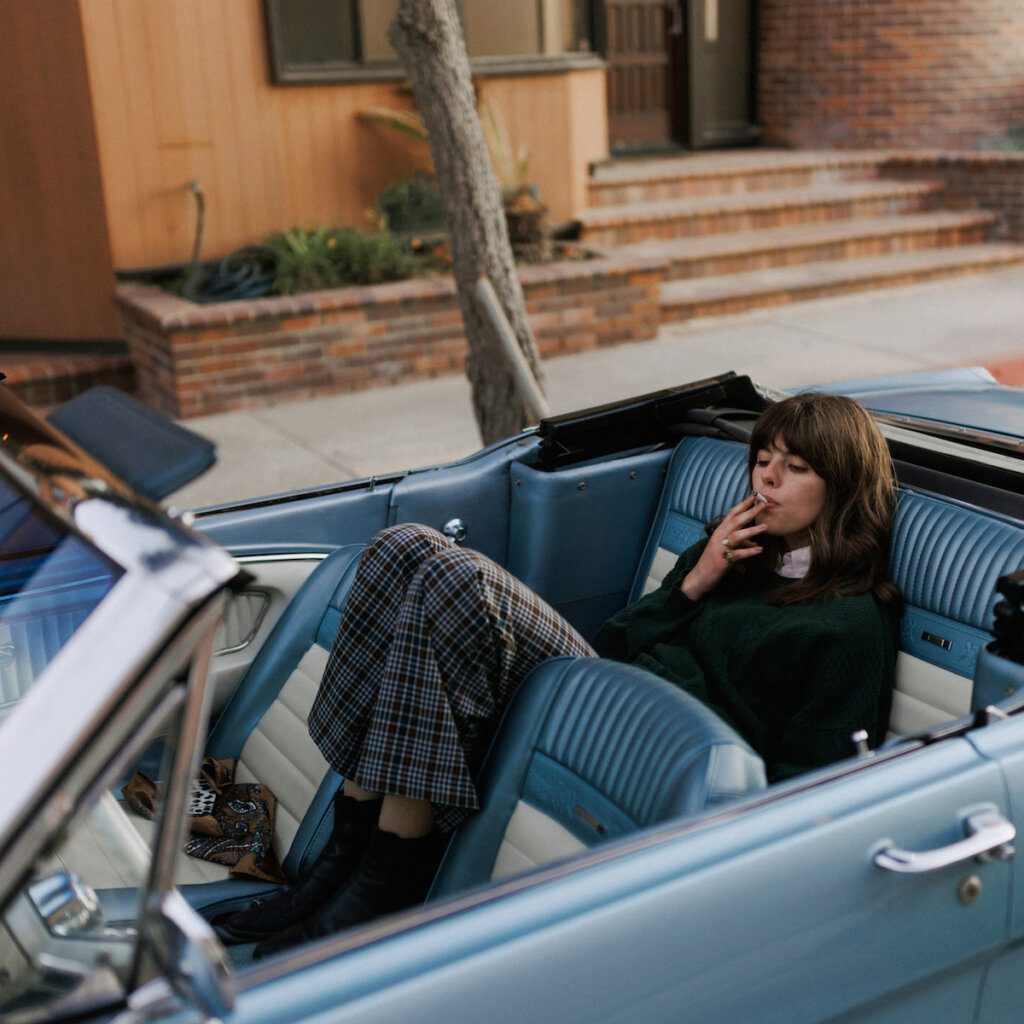 A Teenage Girl Relaxes In A Baby Blue Car