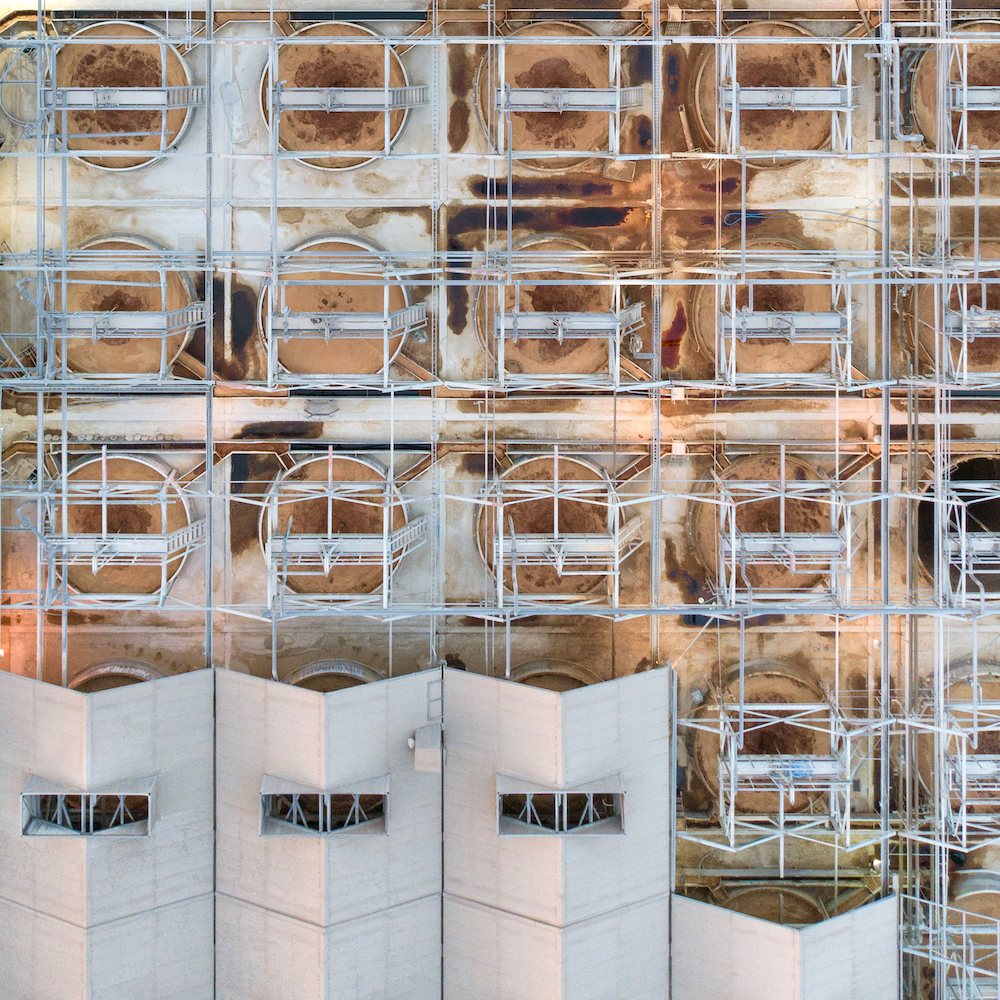 A Building Under Construction, With A Large Part Of The Façade Covered By Metal Scaffolding