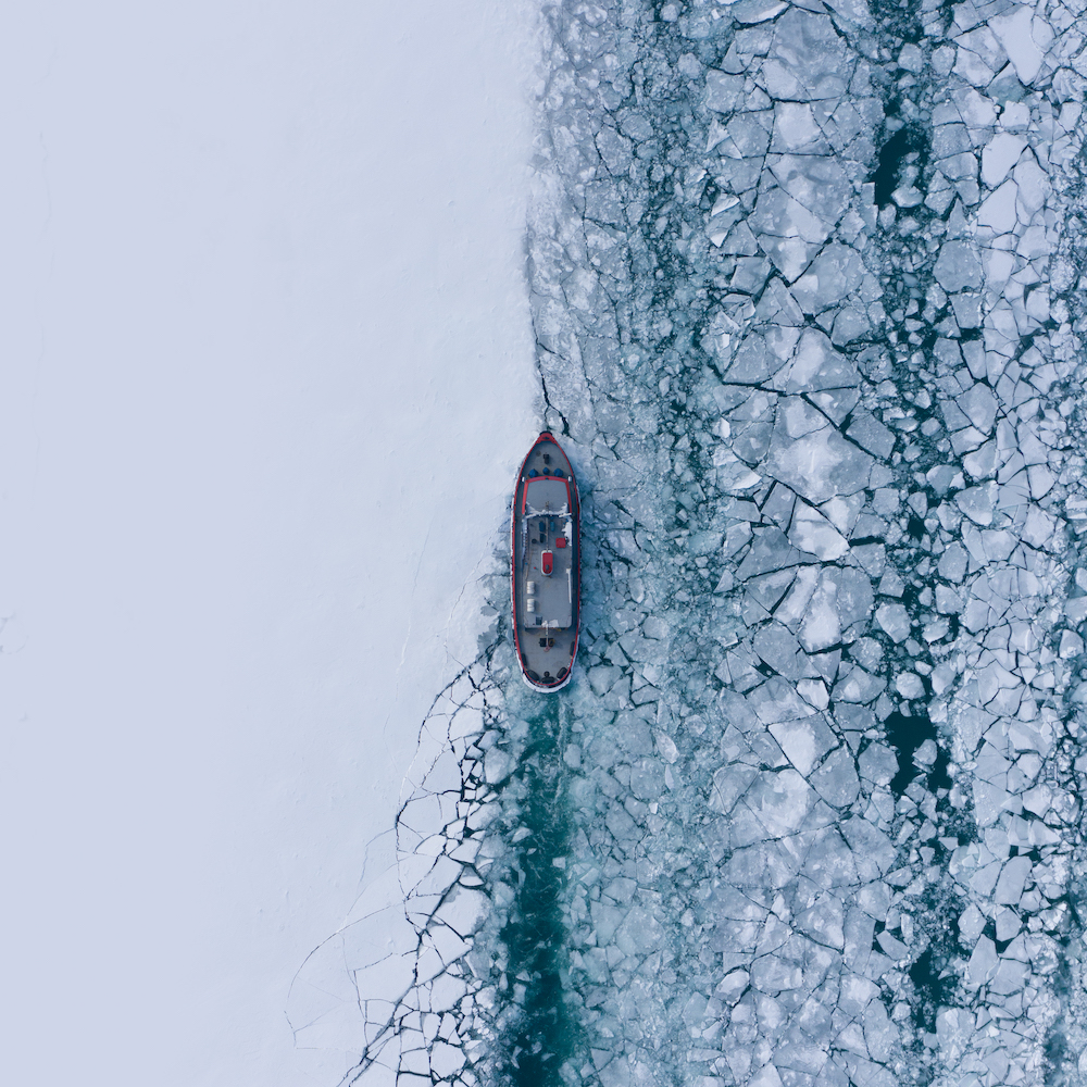 Aerial Shot Of An Icebreaker Boat Clearing A Path Through Icy Waters