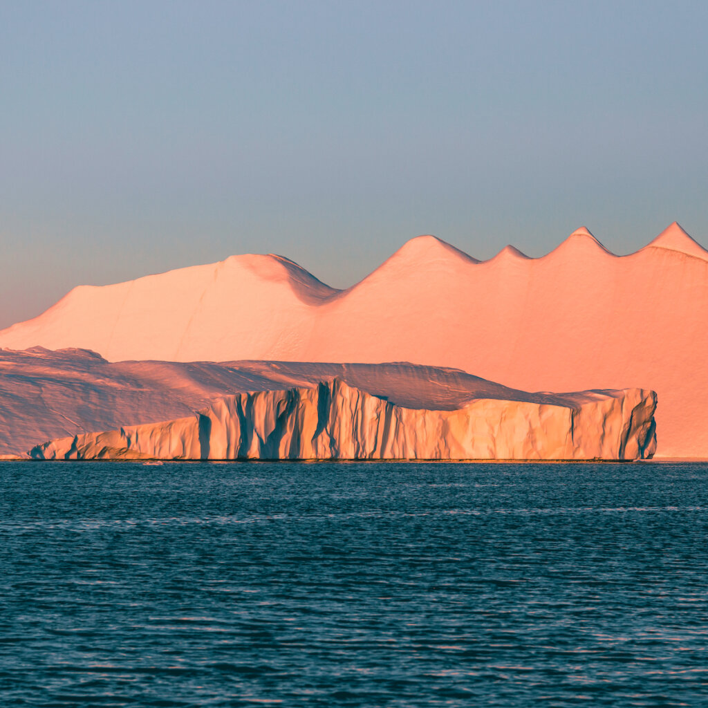 Open Sea With Huge Mountains Of Ice In The Background